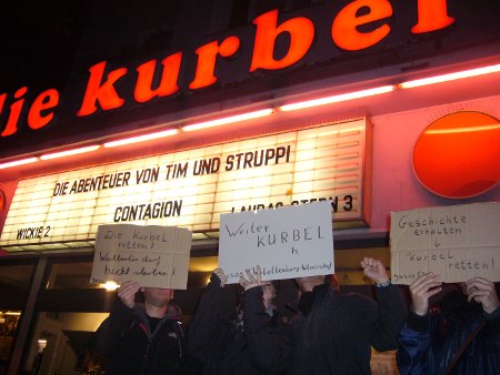 Solidaritätsaktion der Jusos vor Der Kurbel Das Foto zeigt drei Demonstranten vor dem Kino Die Kurbel, die für dessen Erhalt demonstrieren.